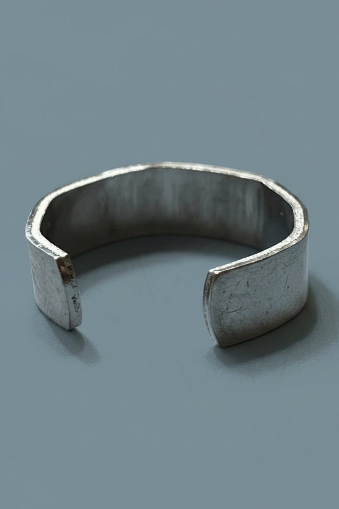 Silver color cuff ring on a light gray background.
