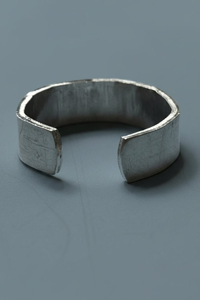 Silver color cuff ring on a blue-gray surface 