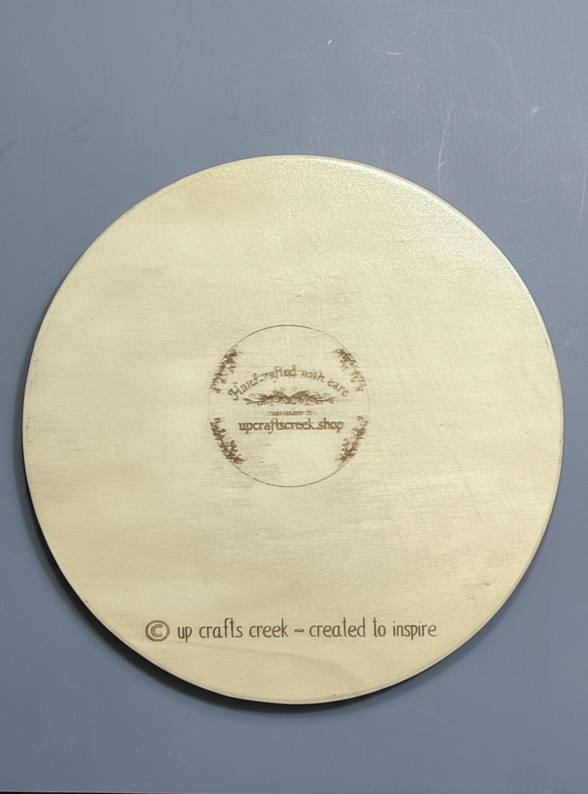 Back of round wooden plaque with makers mark for Up Crafts Creek