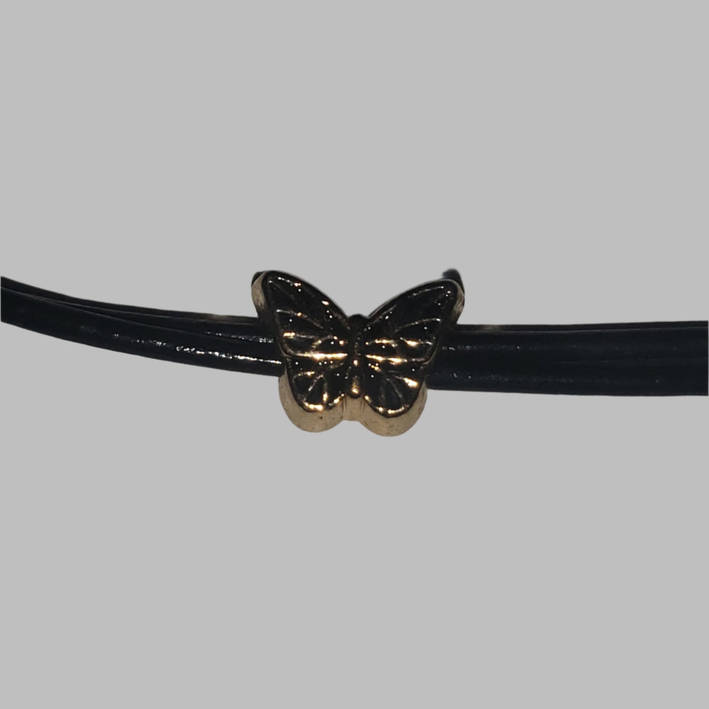 Black leather necklace with a gold butterfly charm