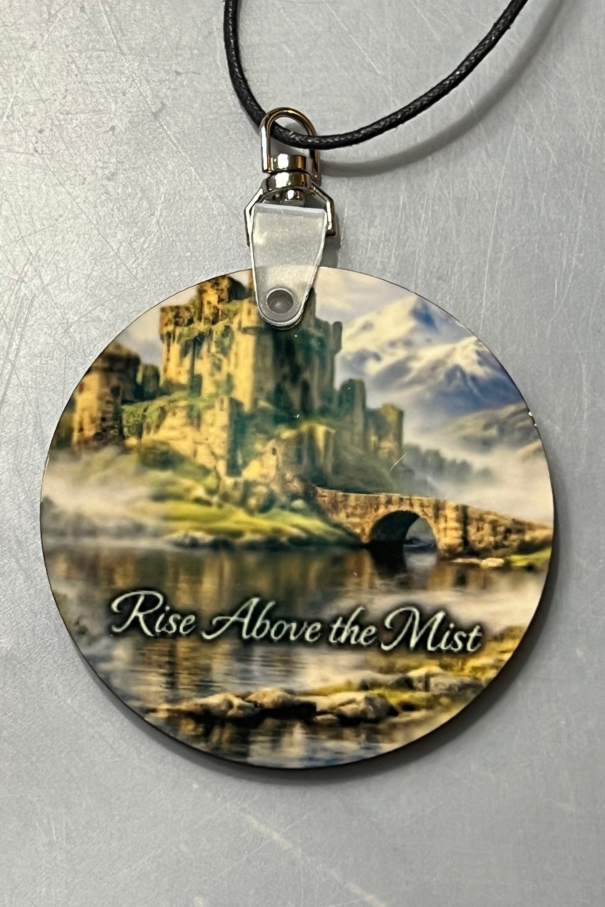 Castle Swivel MIrror Hanger with metal swivel and black cord.
