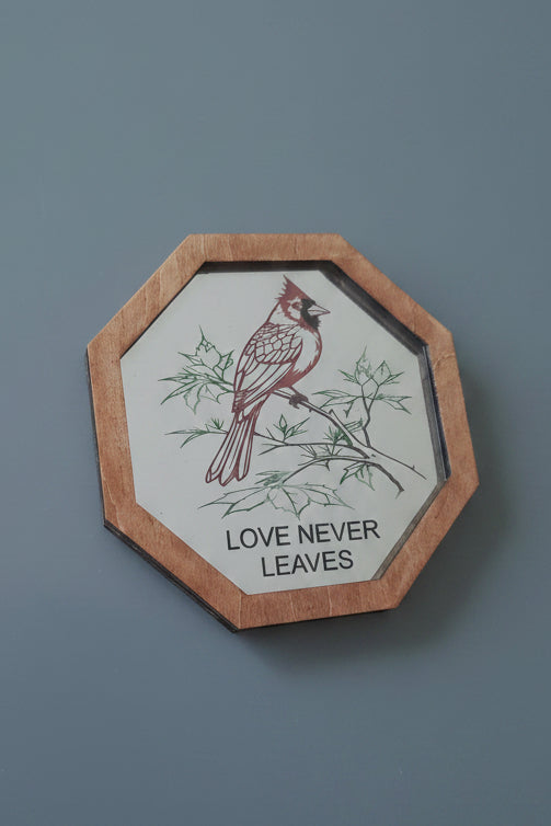 Decorative wall mirror with a cardinal illustration and 'Love Never Leaves' text hand painted etching in a wood frame.
