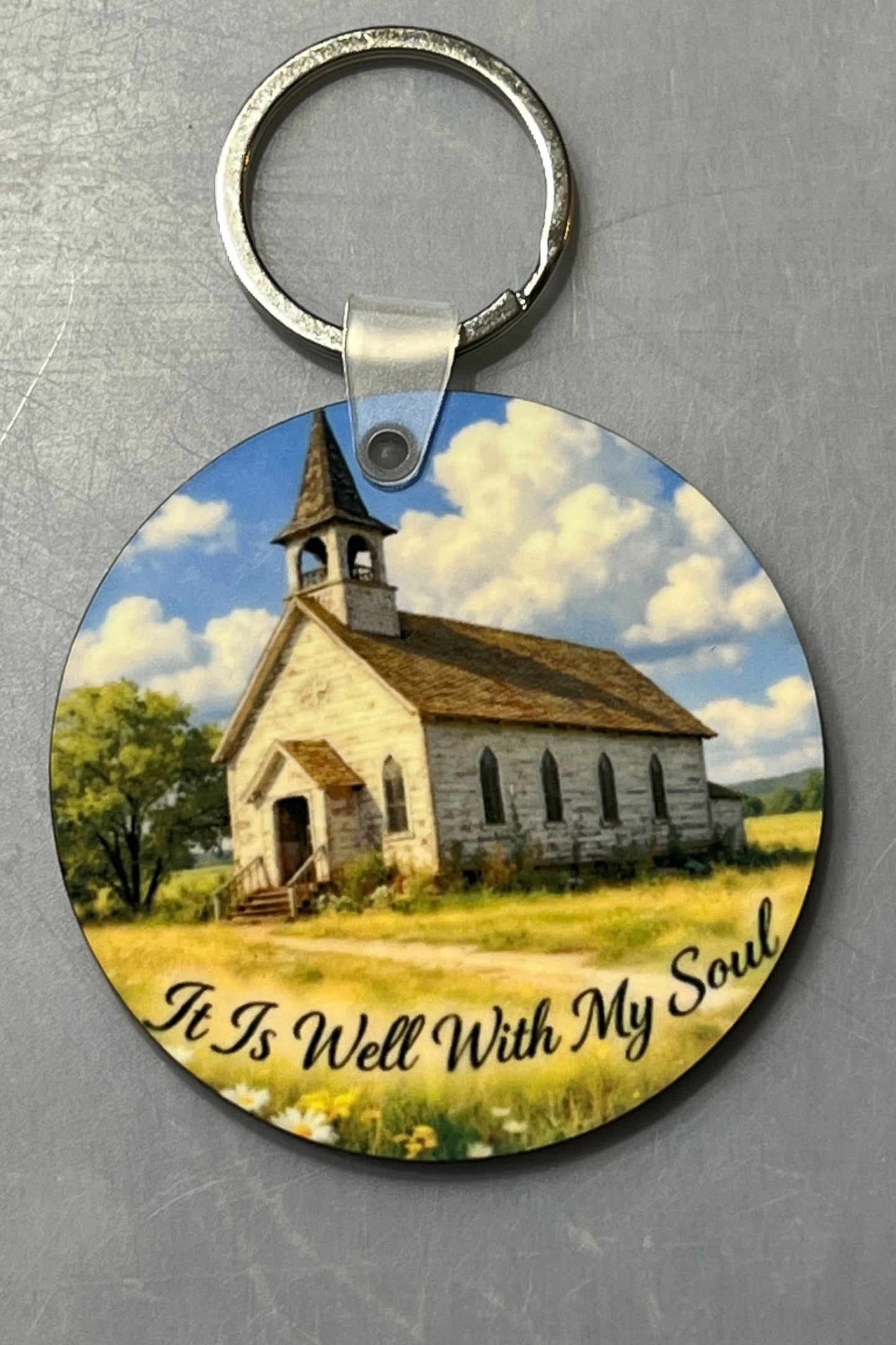 Keychain featuring a quiet country church with the text saying 'It is well with my soul'