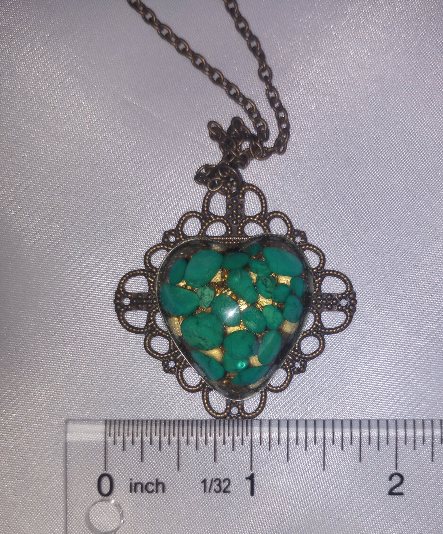 Éclats de pierres précieuses de couleur magnésite turquoise dans un cœur en résine monté sur un collier en filigrane de couleur bronze antique en forme de diamant de 18 pouces 