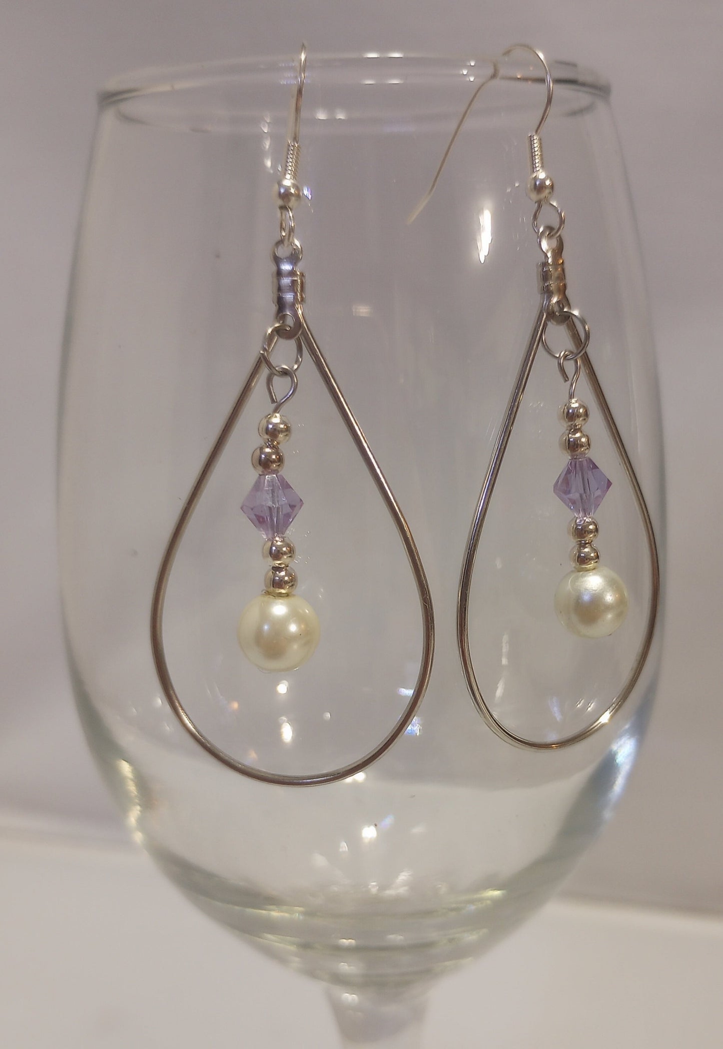 Aros con forma de lágrima con cuentas bicono facetadas de color púrpura y perla y alambres chapados en plata de ley