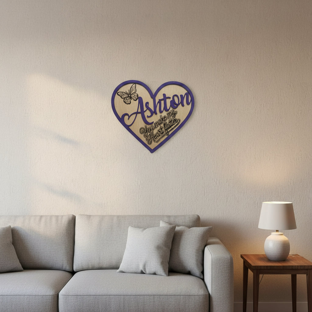 Wooden wall plaque with the name 'Ashton' overlaid in purple, a butterfly and text stating 'You make my heart flutter' is burned into the wood beneath the overlay, this two layer design gives a 3D effect and depth to the decor