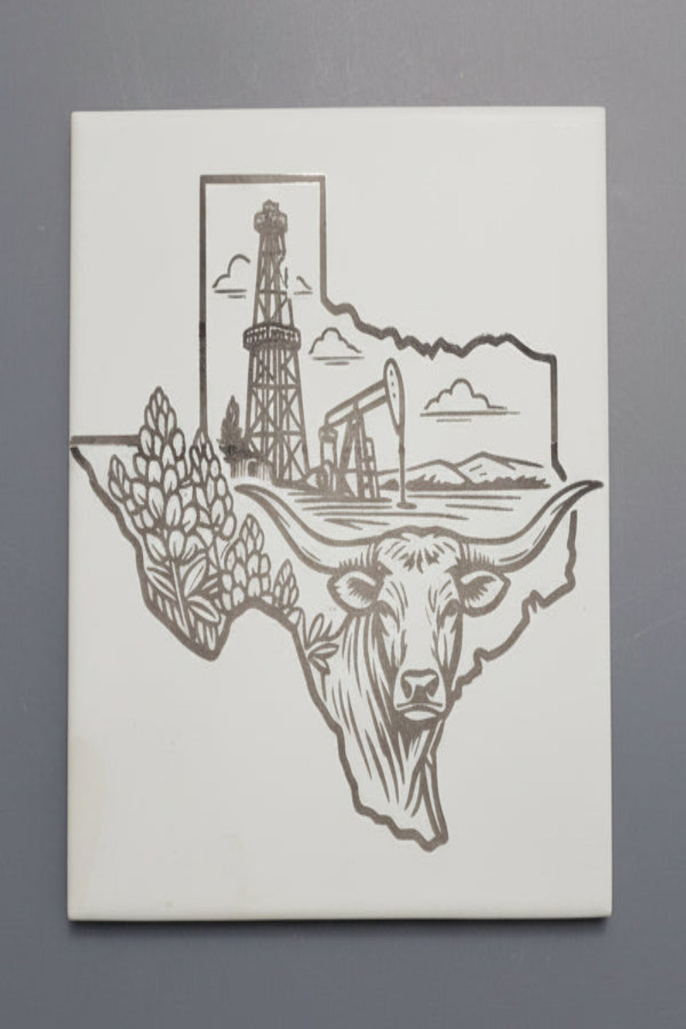 interchangeable ceramic tile for trivet hot plate with a Texas-shaped design featuring a cow head, oil derrick, and pumpjack 