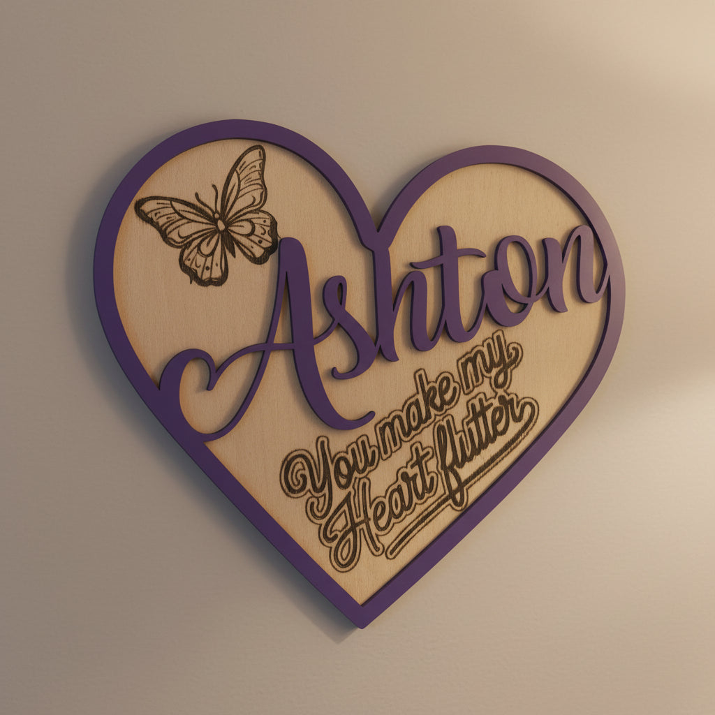 Heart-shaped decorative sign showing the name 'Ashton' and a butterfly design with the slogan 'you make my heart flutter' on a beige background